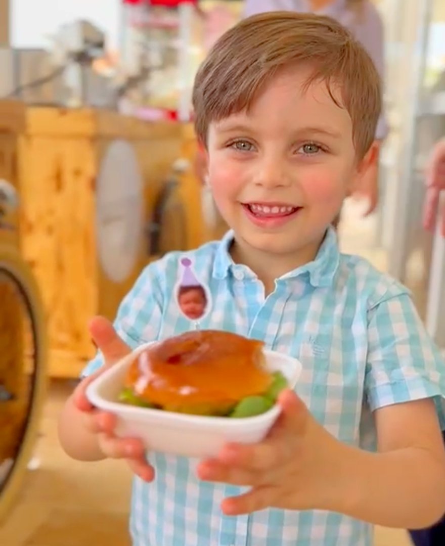 Menino feliz com mini hambúrguer